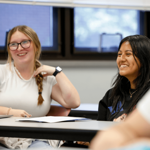 Two students smiling during class