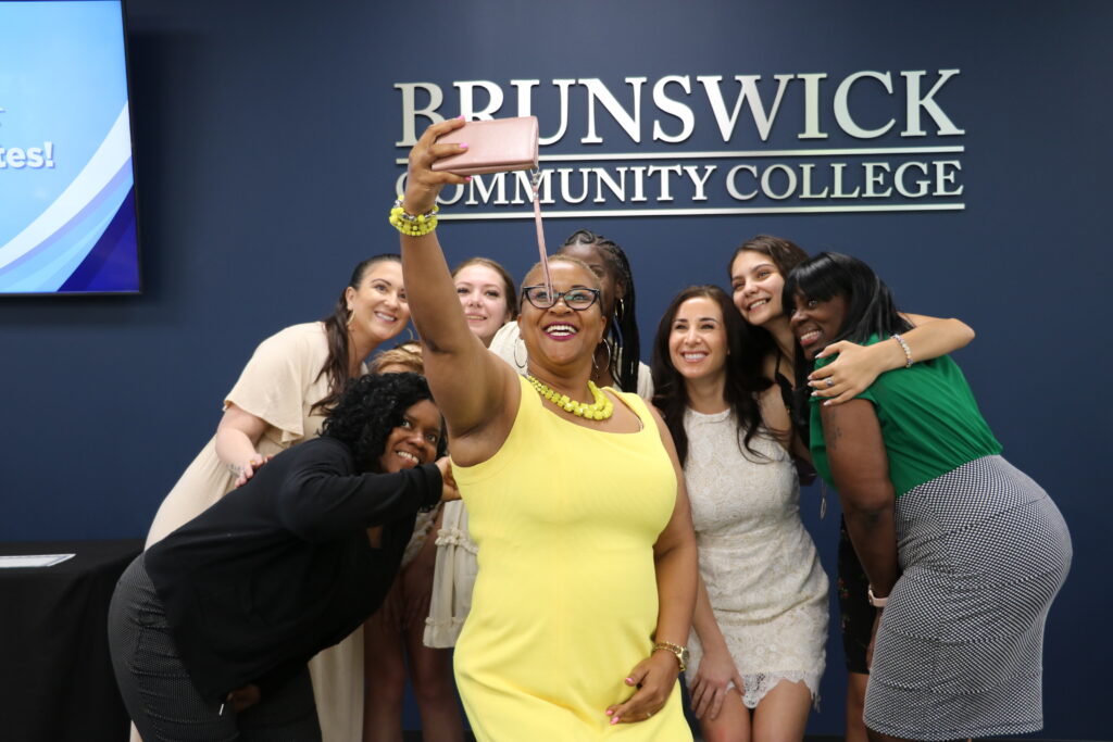 dean and esthetics grads posing for selfie