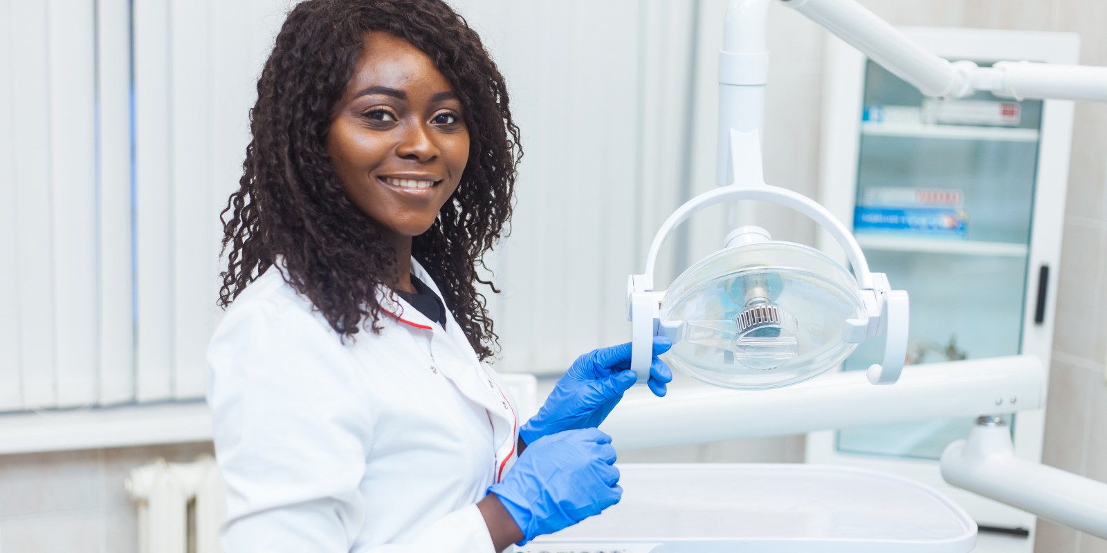 an African American Dental Assistant Student adjusting a light in a dental office