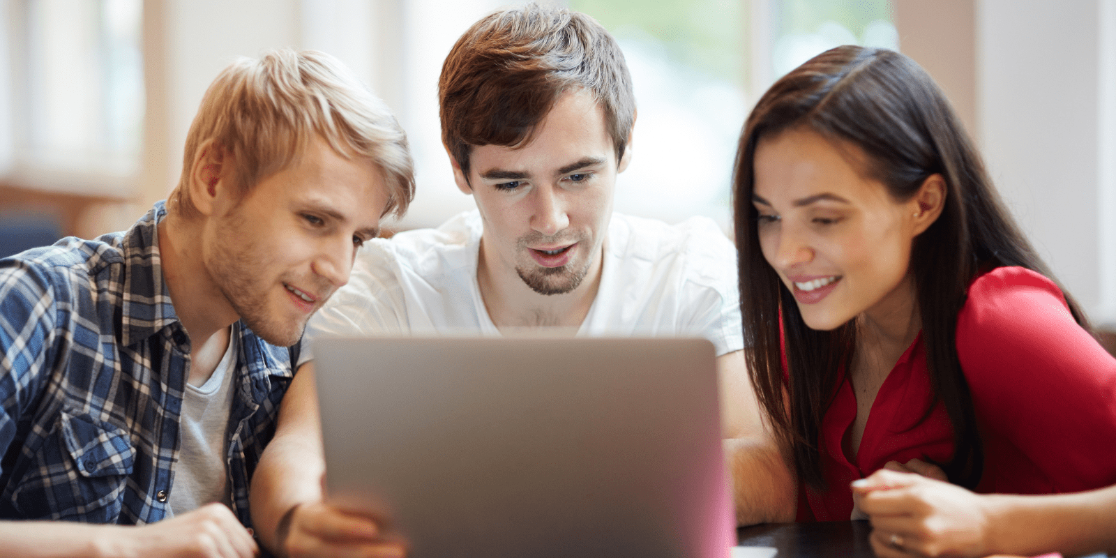 three computer science students in front of a laptop