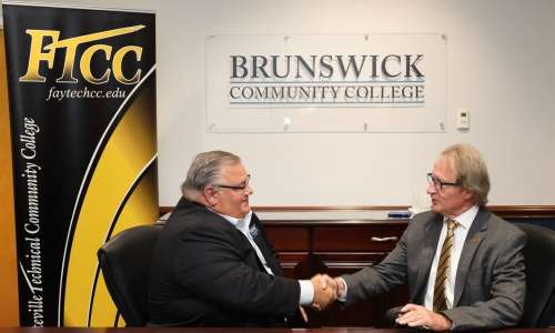 The presidents of BCC and FTCC shaking hands after signing an agreement for a Funeral Services program