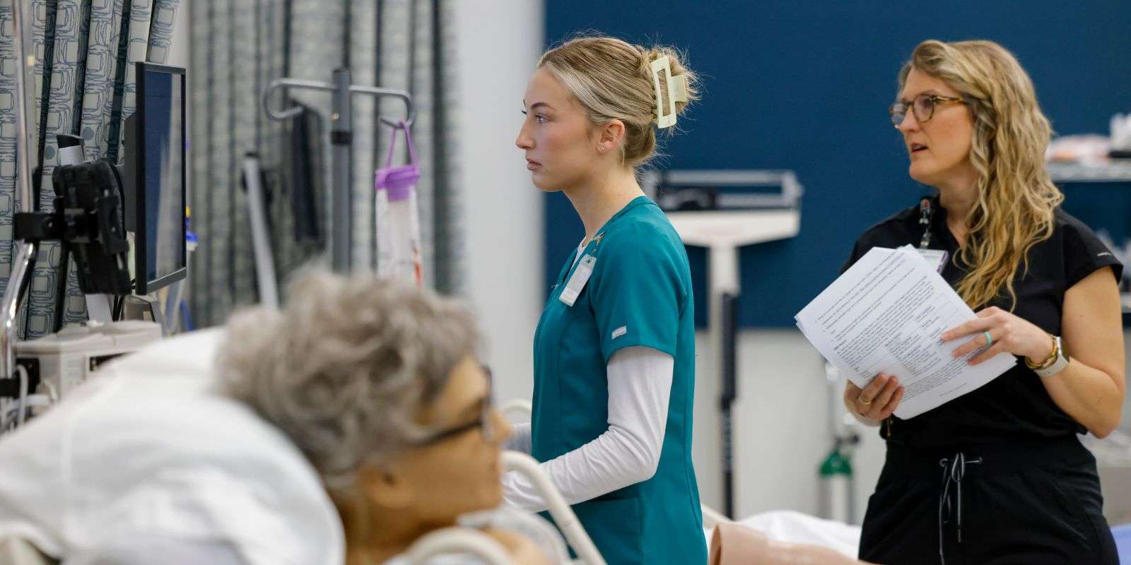 A nursing instructor and student in simulation lab