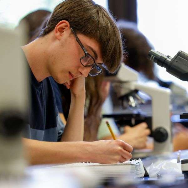 Male student writing in a notebook