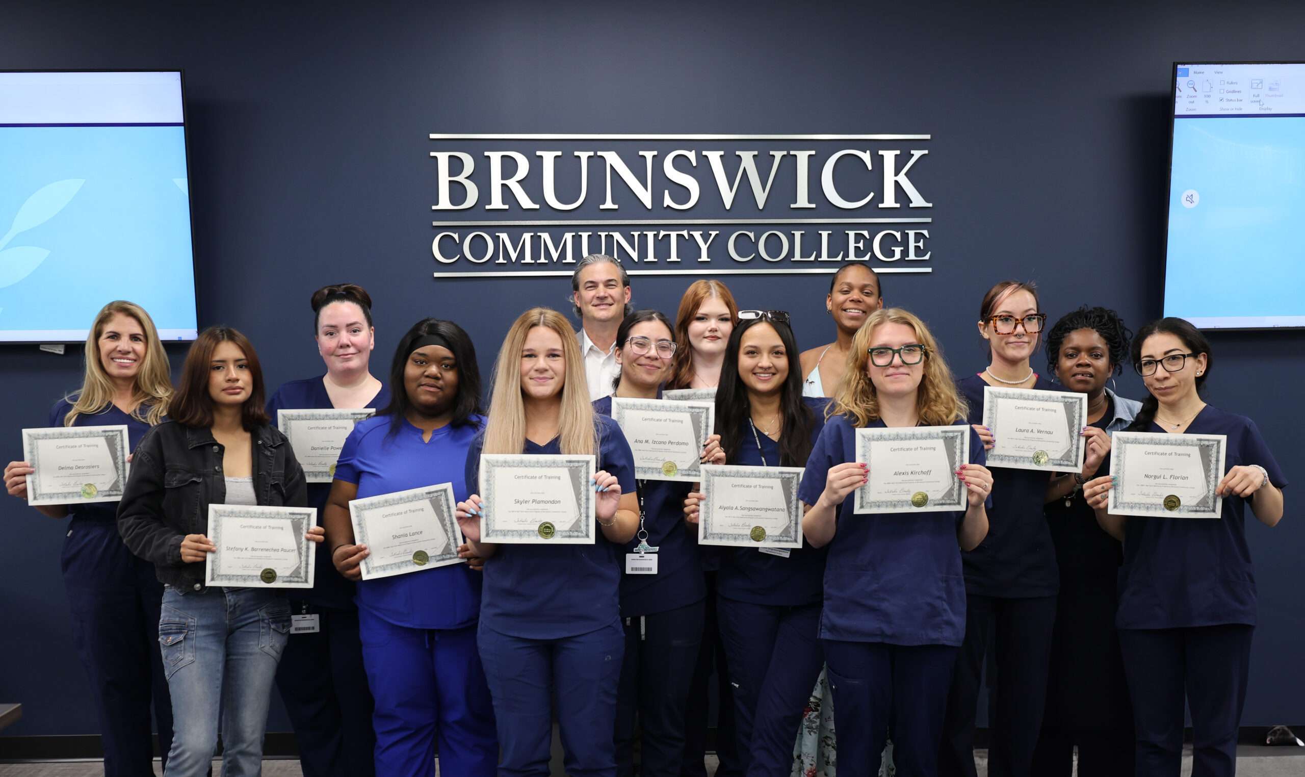 Manicurist program graduates displaying their certificates in a group photo