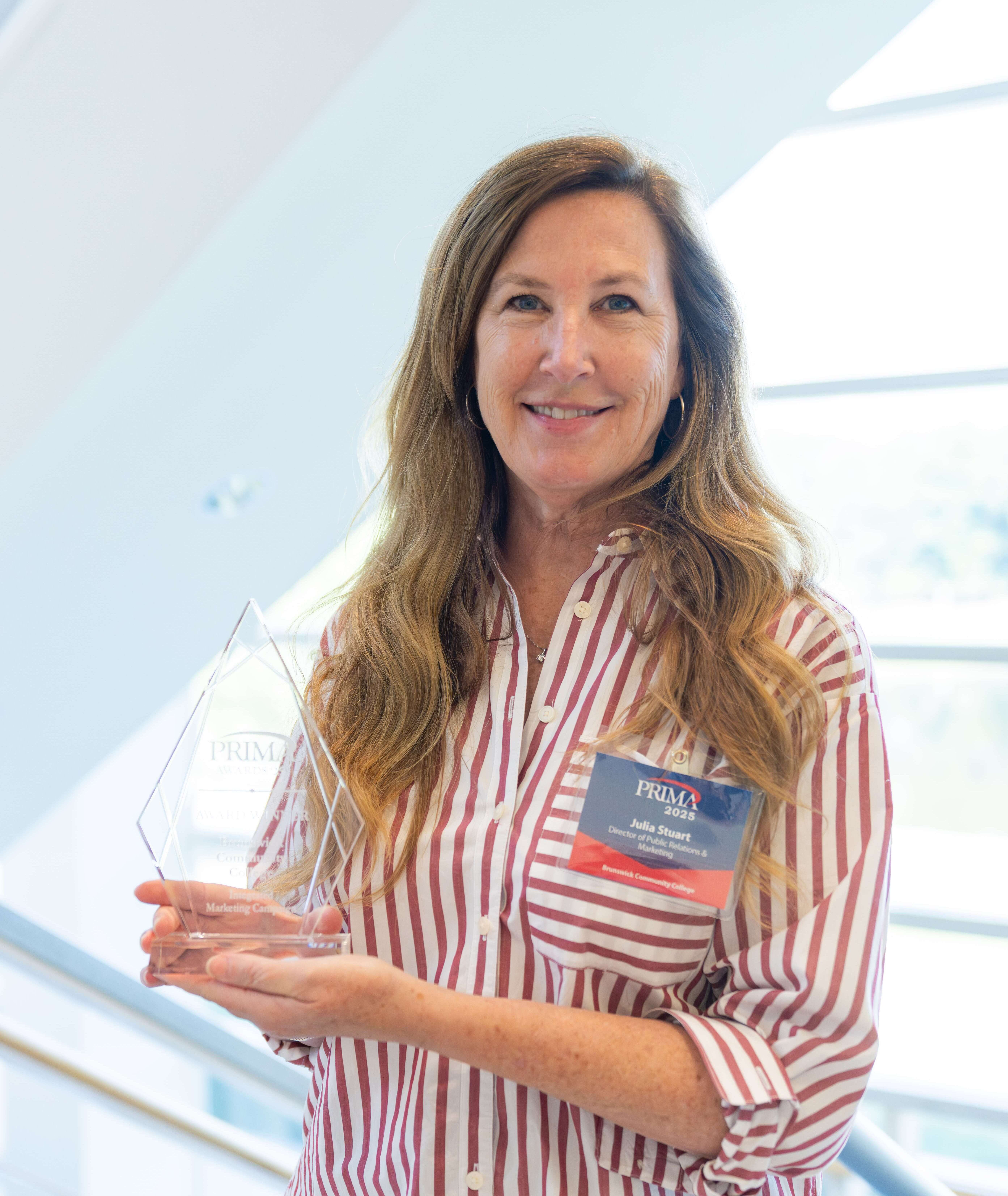 Julia Stuart holding an award for Integrated Marketing Excellence