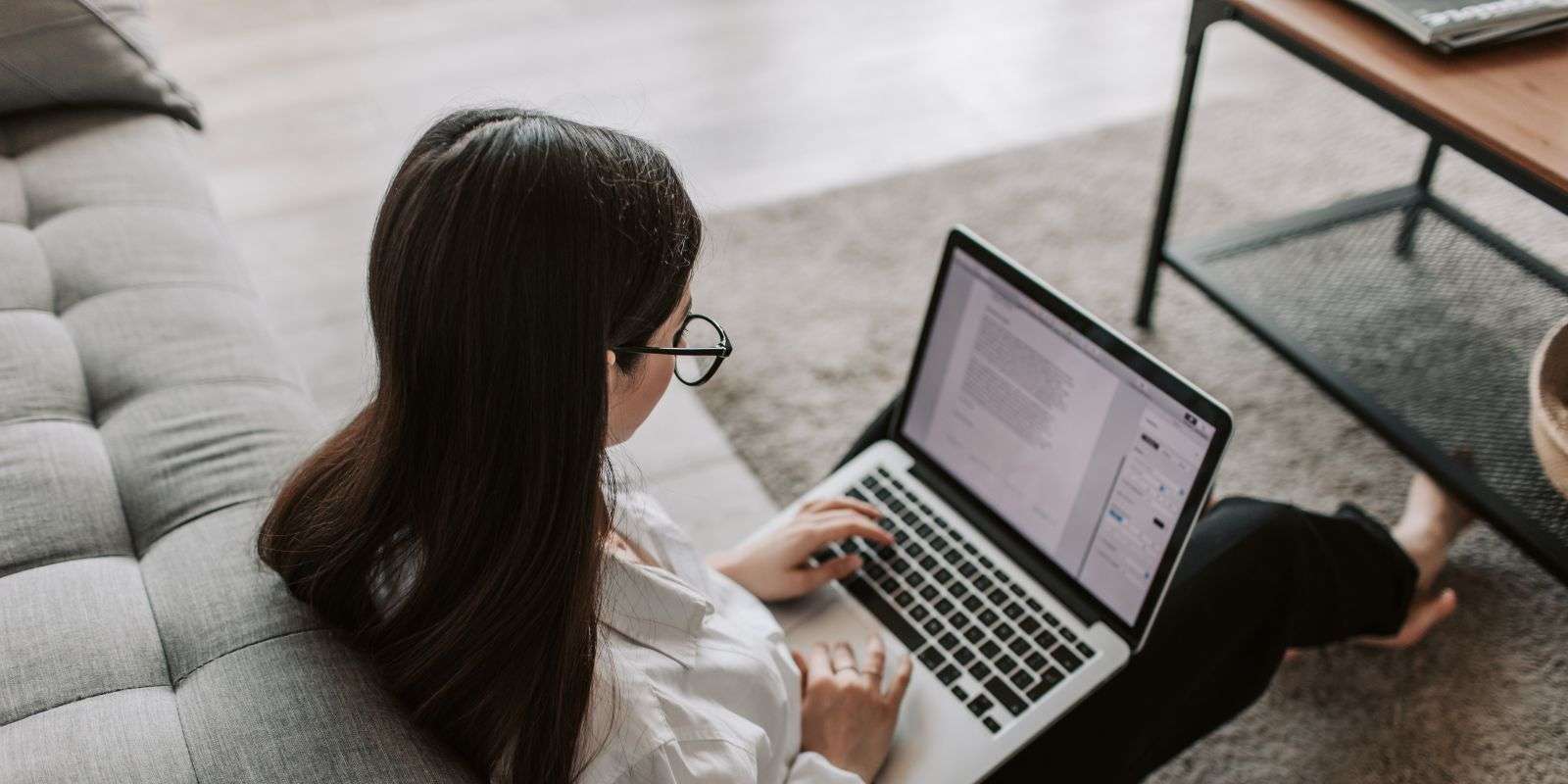 woman sitting on the floor working on her laptop