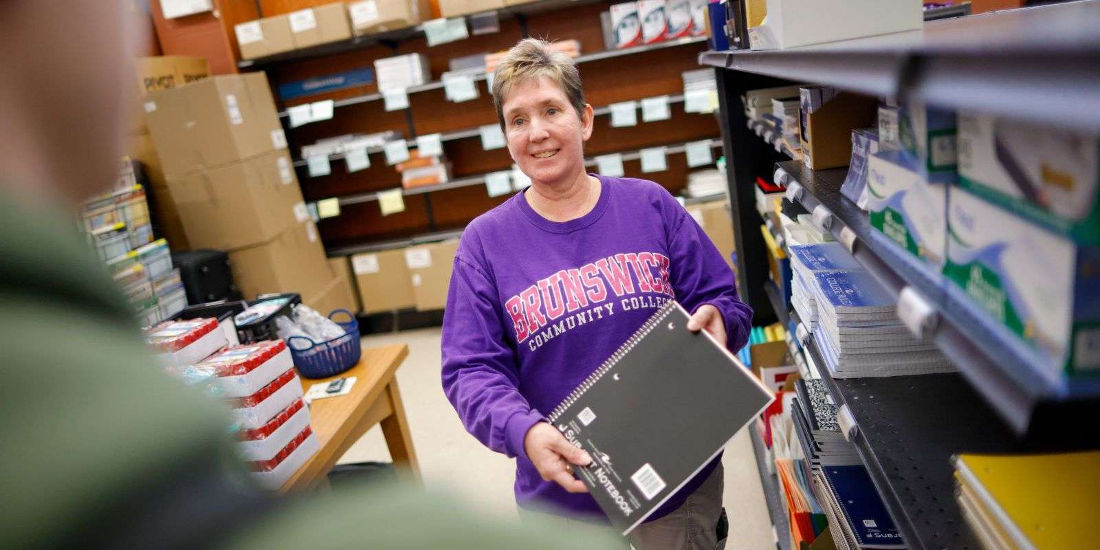 Bookstore employee helping students
