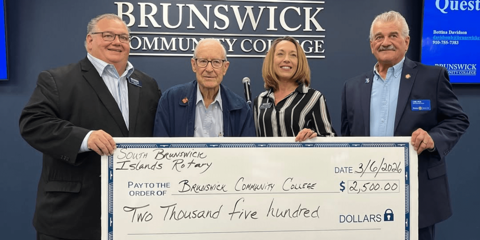 Members of the SBI Rotary Club presenting a check to President SMith and Bettina Davidson