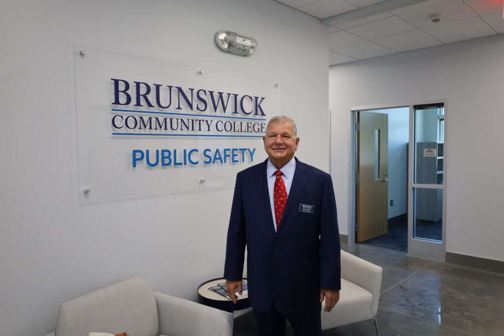 Alan Holden standing in front of a sign