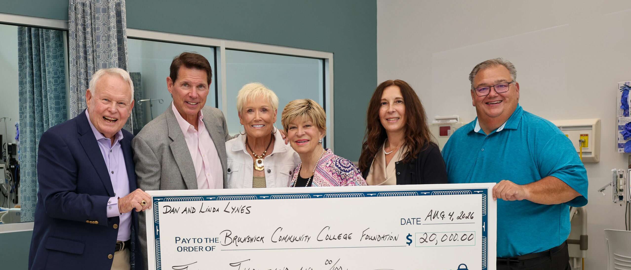Dan and Linda Lynes, President Smith, Gabriella DiSisto, and John and Teri Daly holding a large check